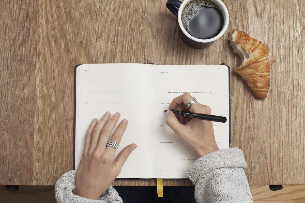 Open notebook and pen used to draft personal project milestones